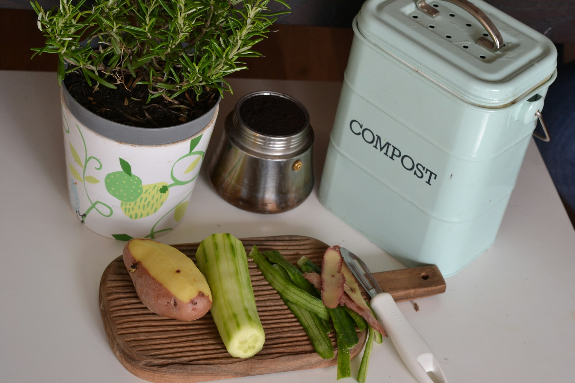 compost bin, cutting board with potato and food scraps